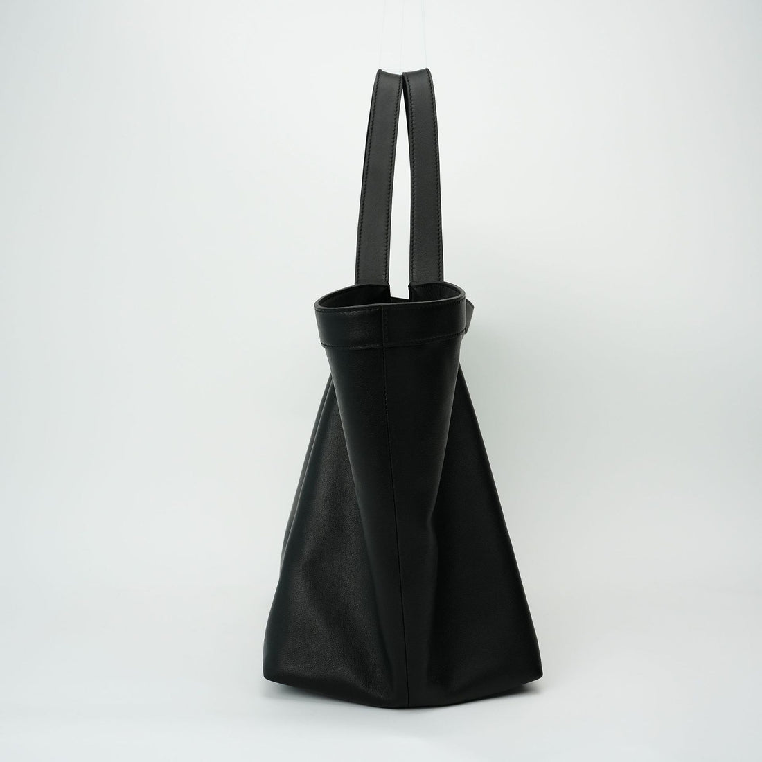 Logo-free black Y-strap slouchy leather tote — side profile