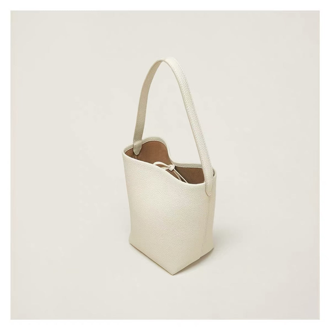 Minimalist tan leather shoulder tote — cream version three-quarter view