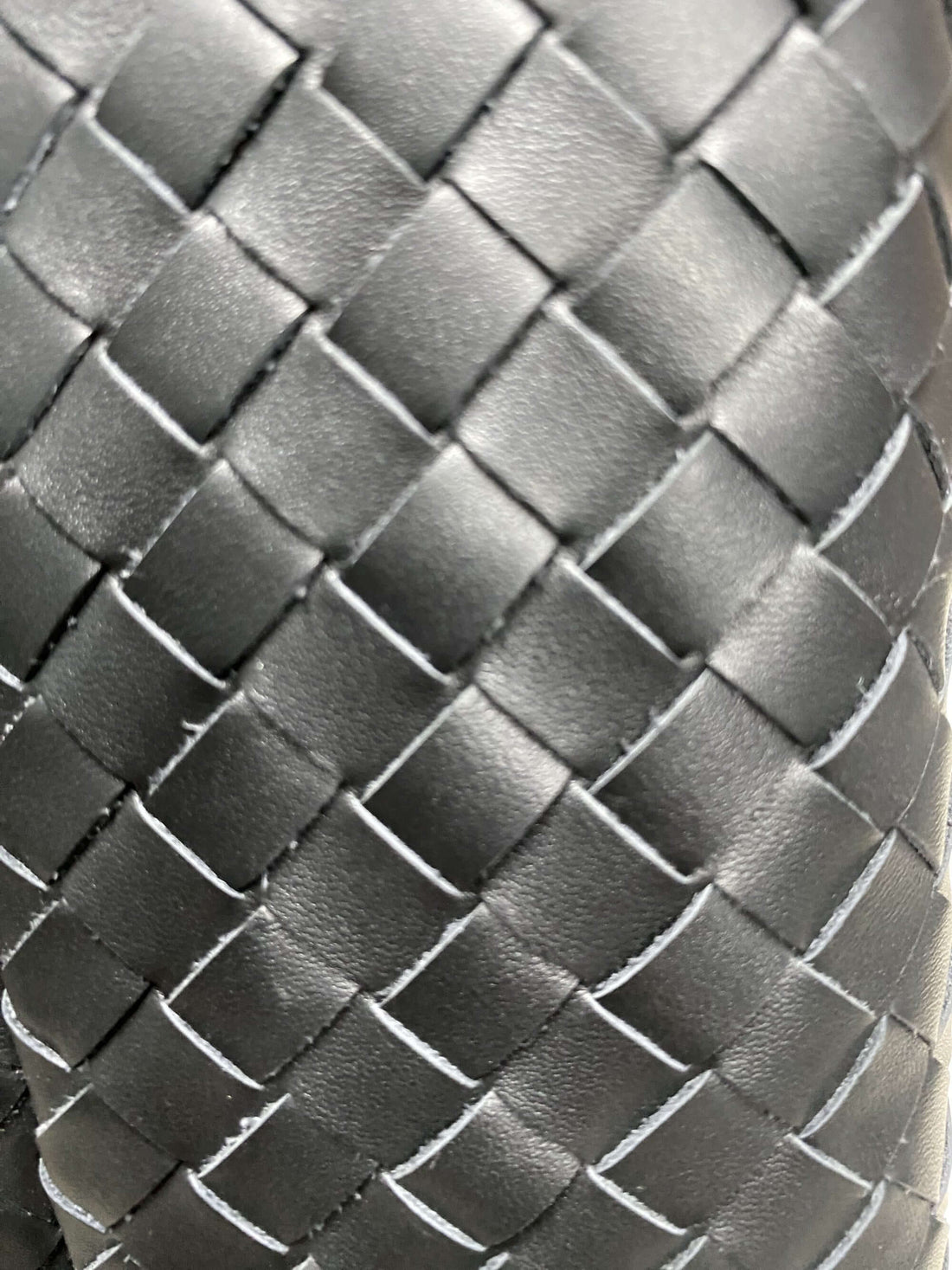 Logo-free top-grain cowhide woven tote — black handwoven leather texture close-up