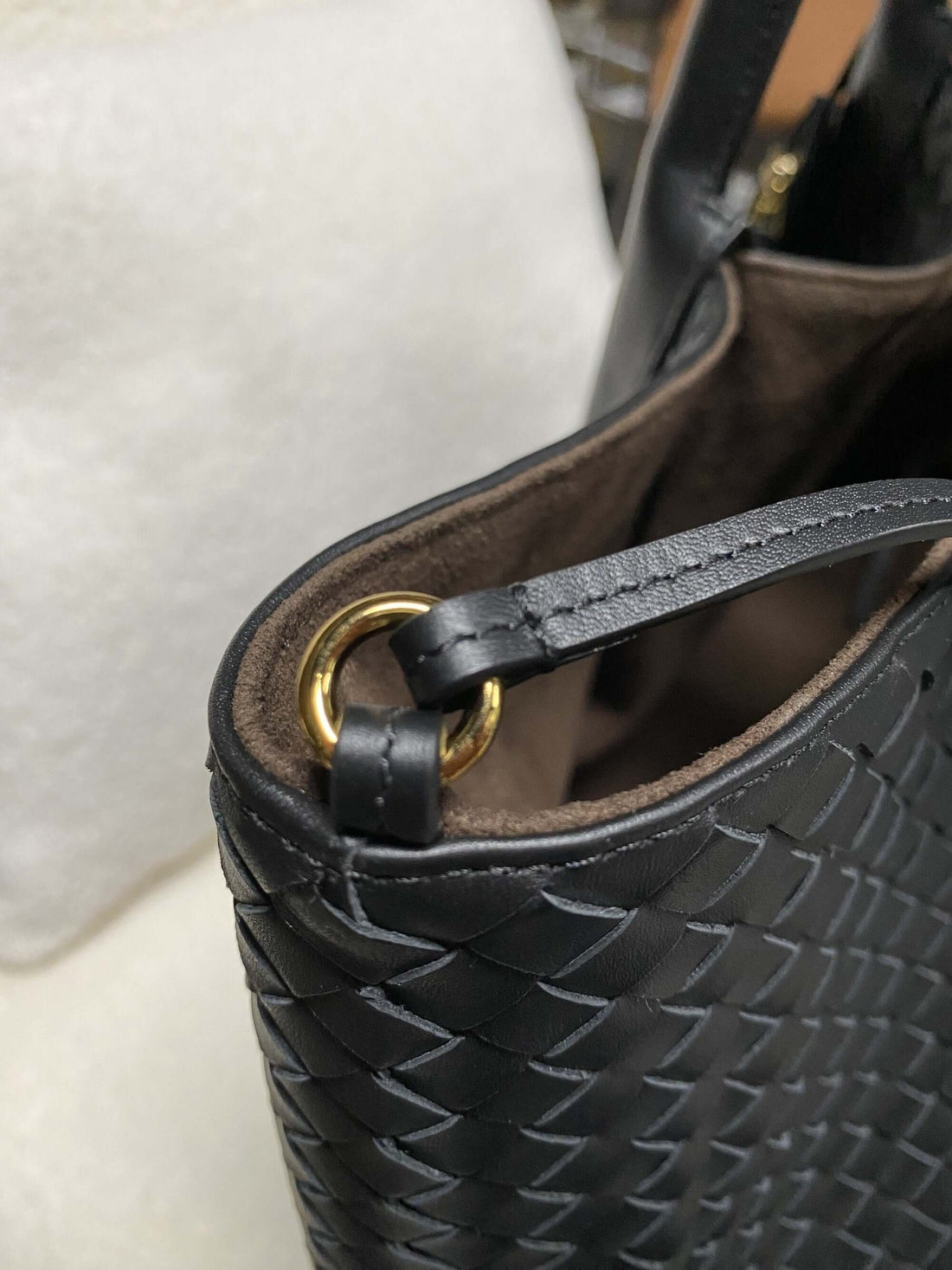 Logo-free top-grain cowhide woven tote — side ring hardware close-up