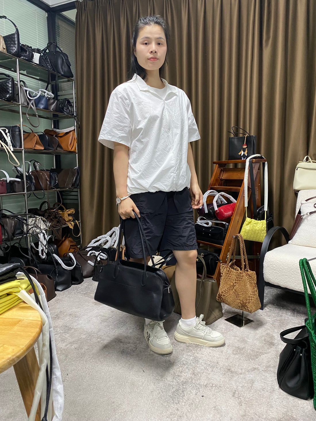 Logo-free black cowhide work tote — carried by a woman in a boutique