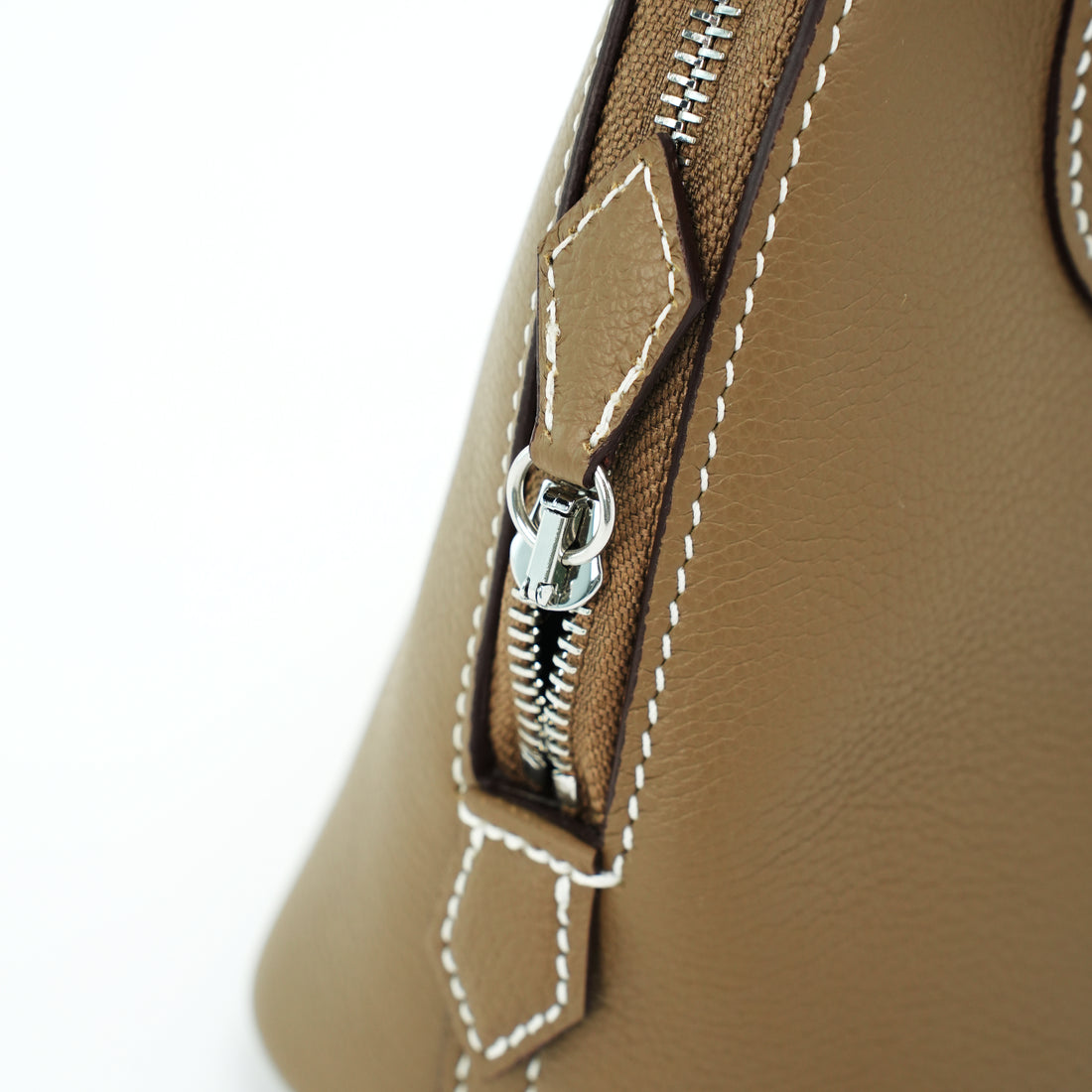 Silver zipper and contrast stitching on taupe leather dome handbag