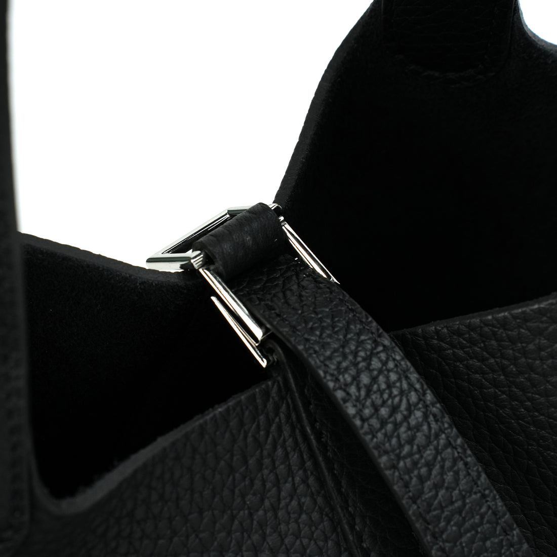 Logo-free vegetable-tanned cowhide bucket bag — black closure hardware close-up