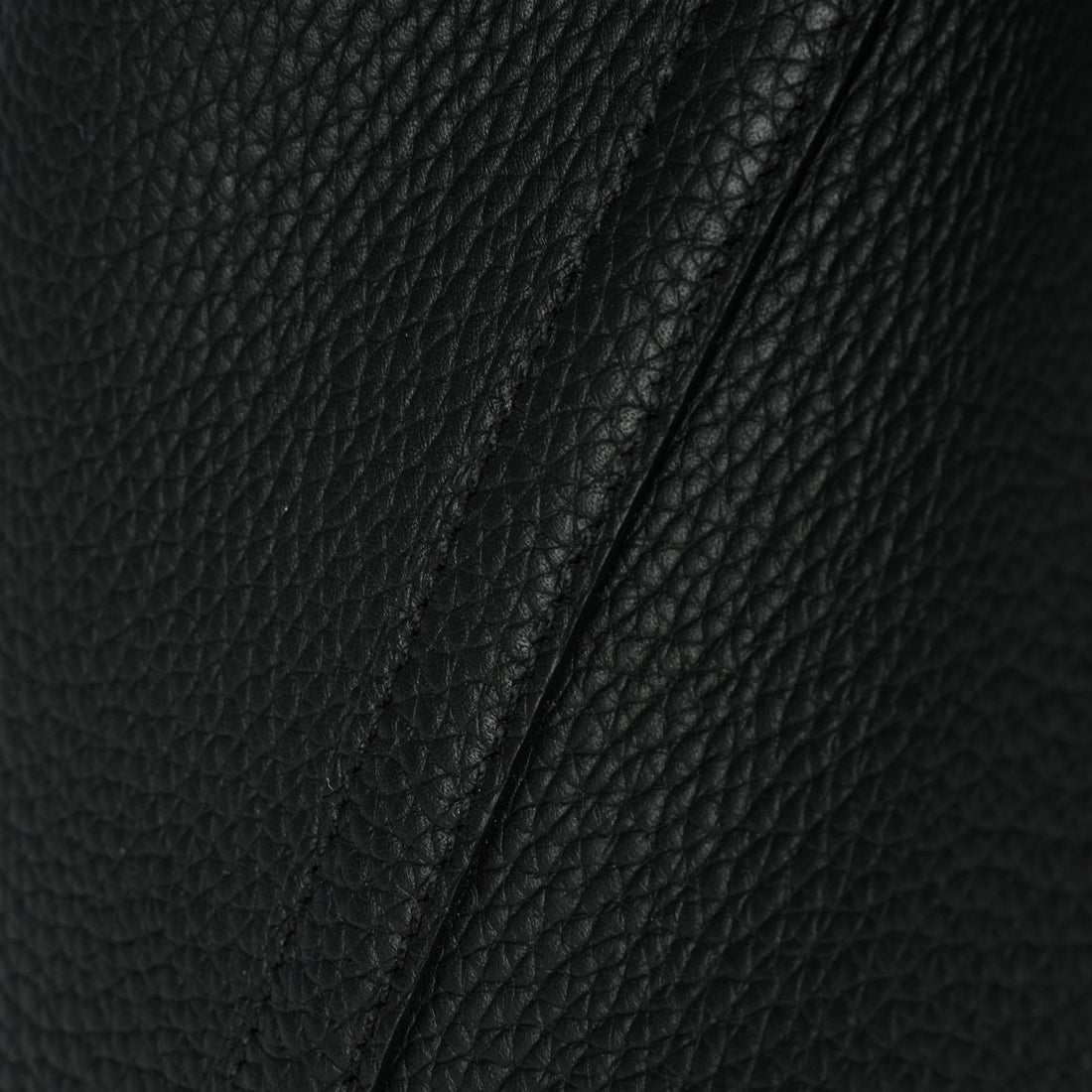 Logo-free vegetable-tanned cowhide bucket bag — black pebbled leather texture close-up