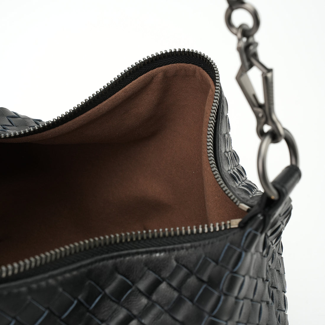 Logo-free handwoven lambskin shoulder bag — black lining and open interior close-up