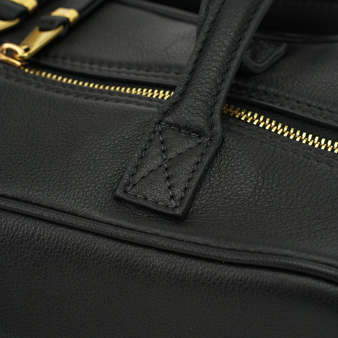 Logo-free cowhide bowling shoulder bag — black zipper and handle stitching close-up
