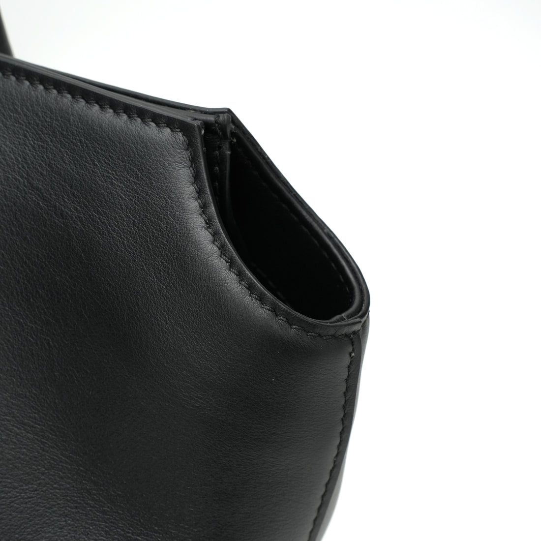 Logo-free full-grain cowhide shoulder tote — black leather side opening close-up