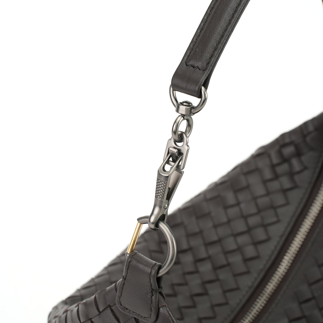 Logo-free handwoven lambskin shoulder bag — black strap clasp close-up