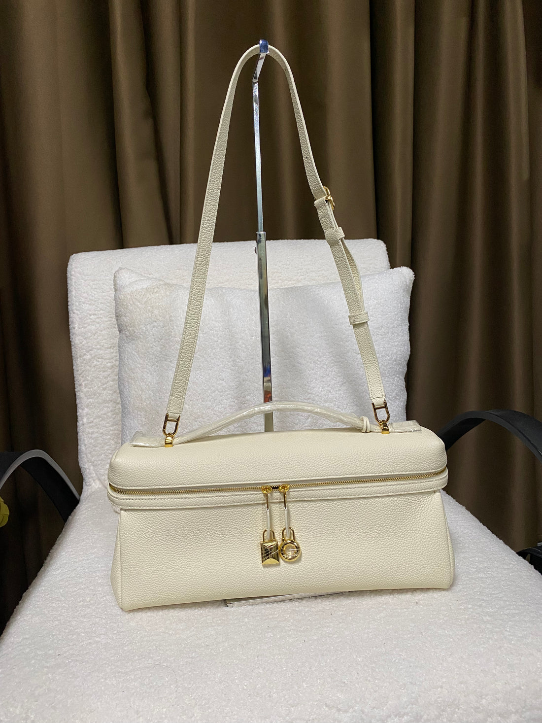 Cream leather shoulder bag with adjustable strap and top handle