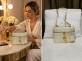Woman using a cream pebbled leather vanity case crossbody bag