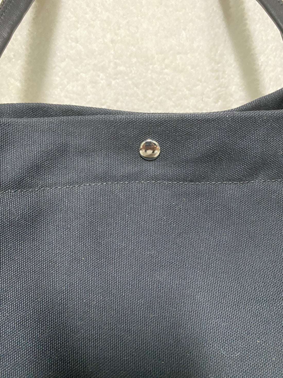 Navy canvas texture and concealed snap closure close-up