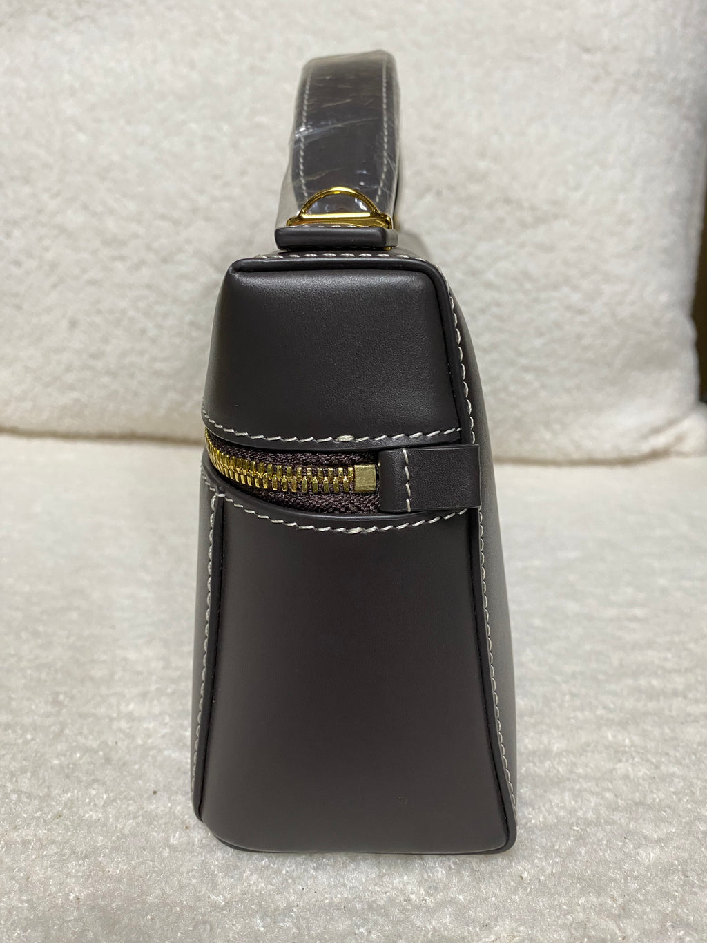 Side view of dark brown calfskin box bag with exterior zipper detail