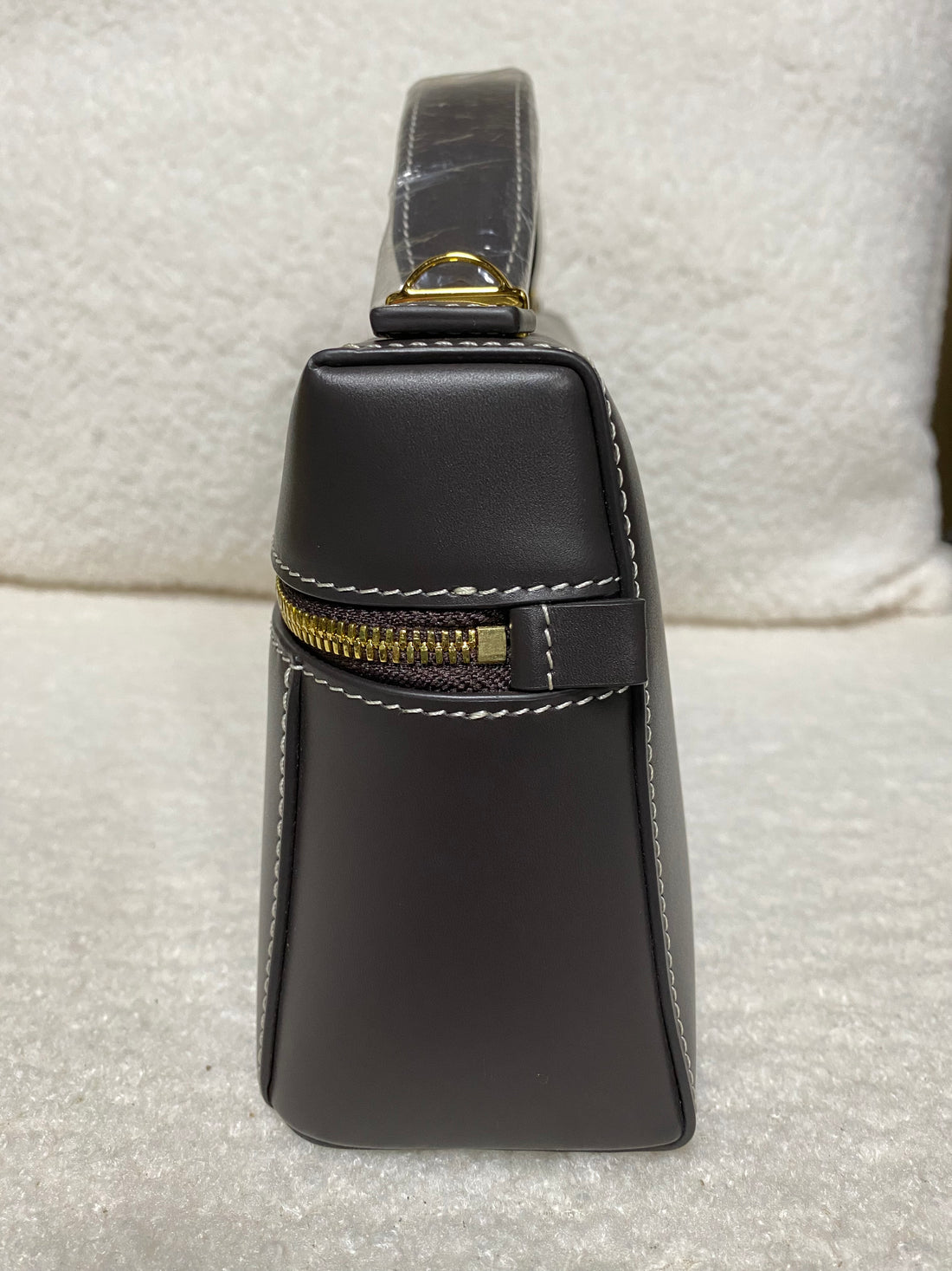 Side view of dark brown calfskin box bag with exterior zipper detail