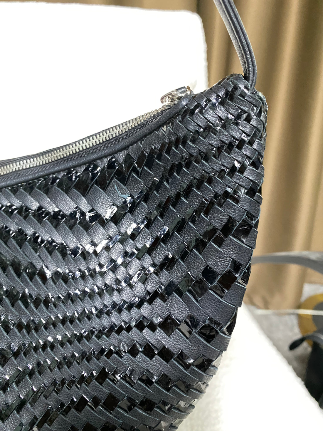 Zip-top edge and mixed-weave leather detail on black hobo bag