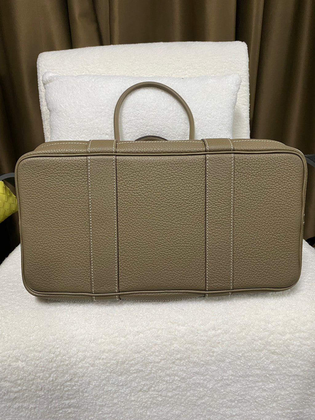 Reinforced base of taupe pebbled leather tote on display