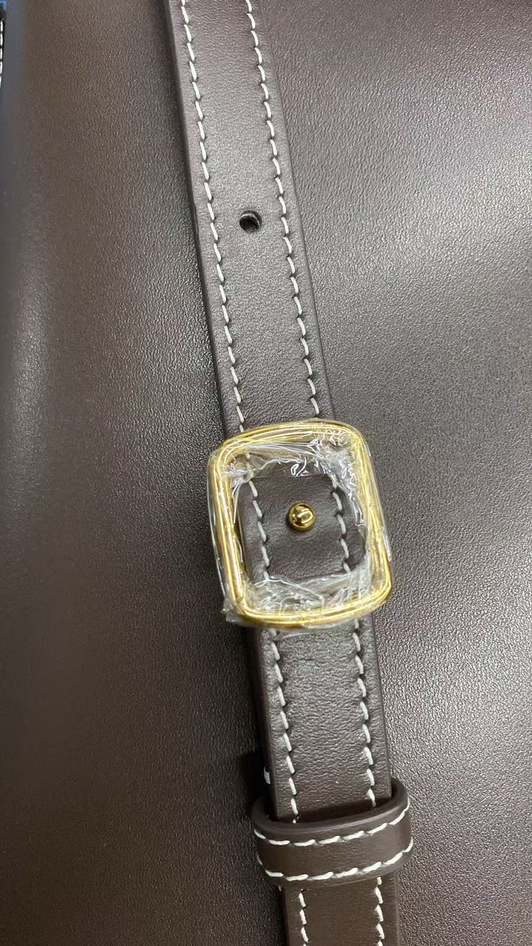 Adjustable leather strap buckle with white contrast stitching