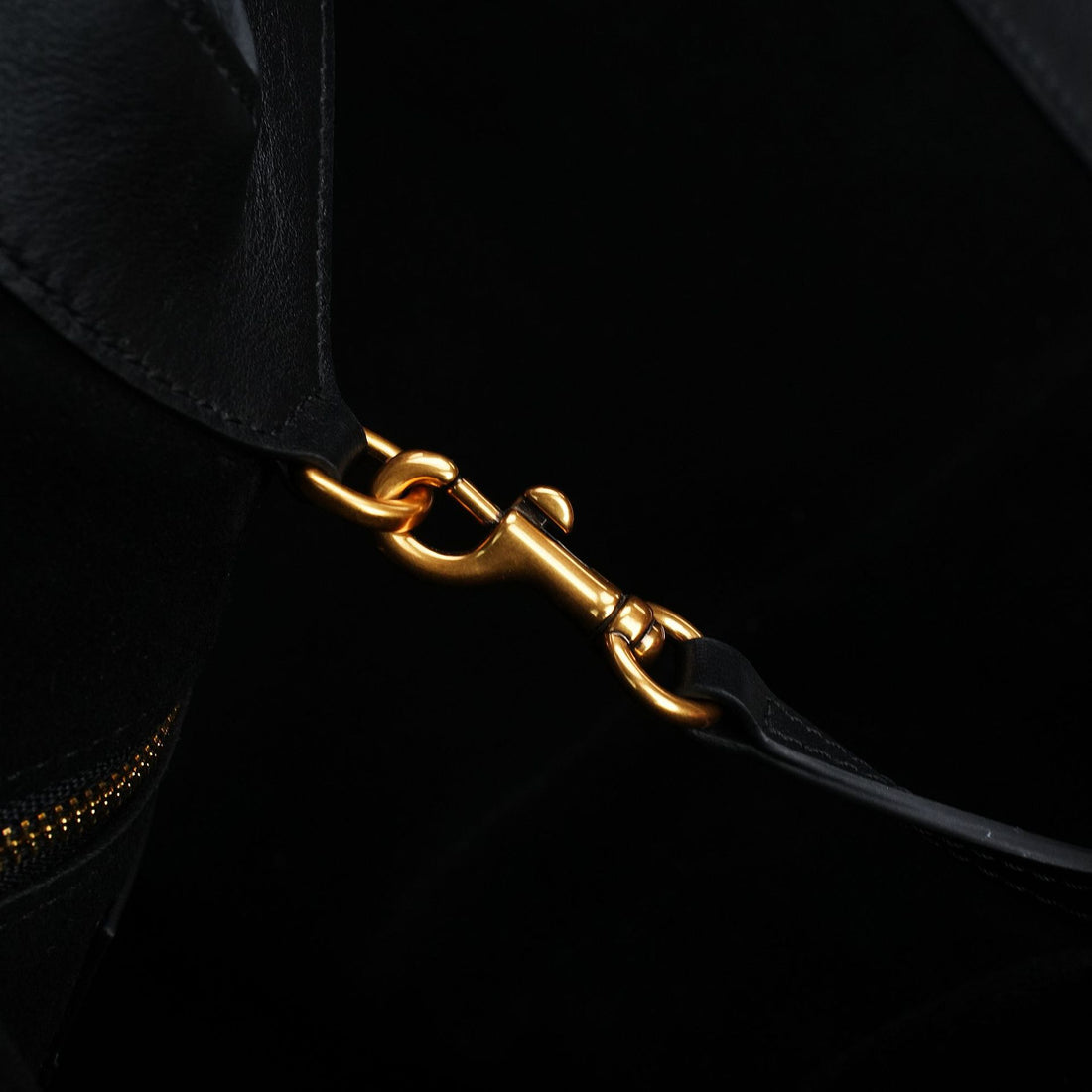 Logo-free black Y-strap slouchy leather tote — gold clasp hardware close-up