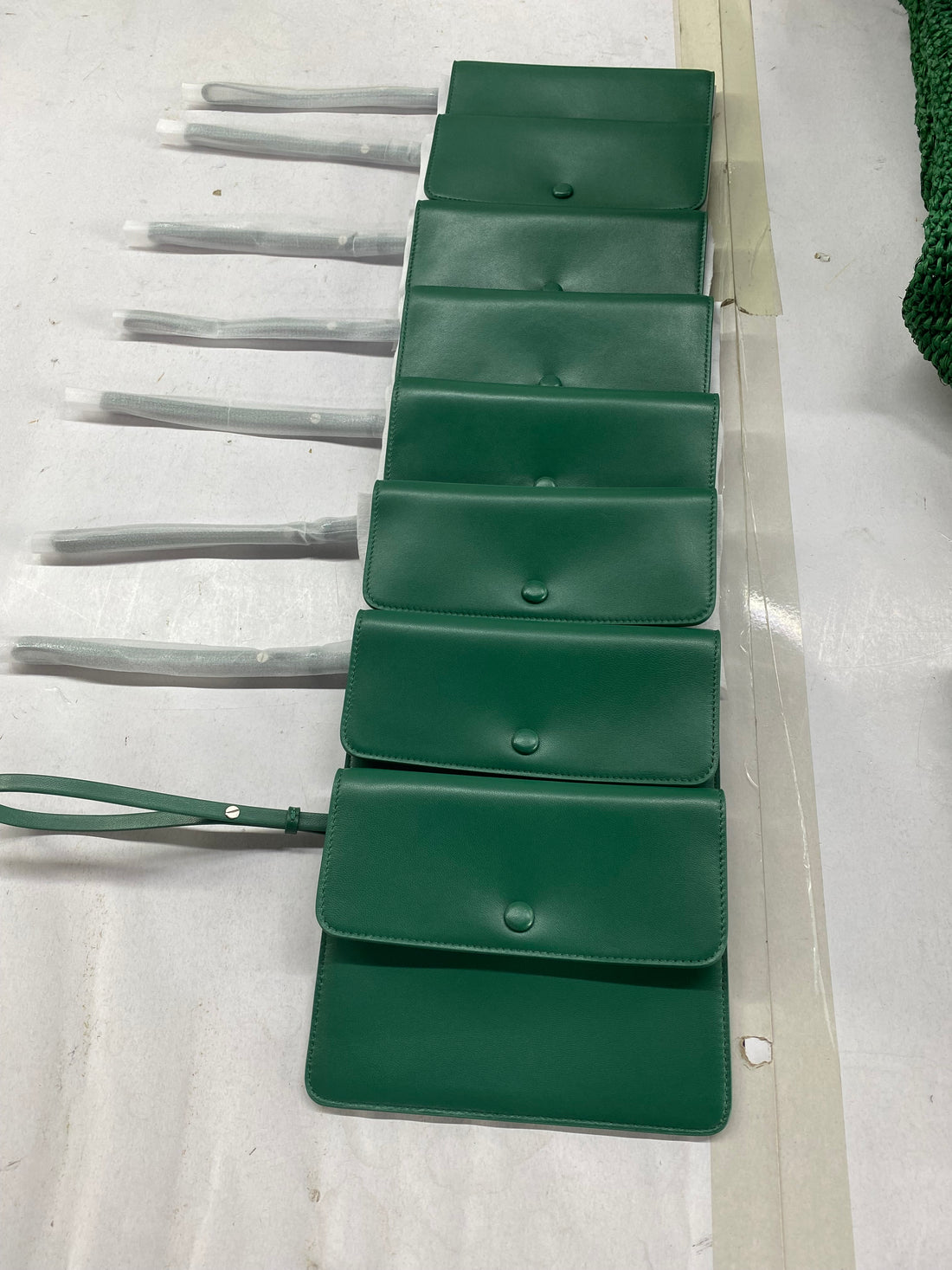Emerald green leather pouches and straps arranged during production