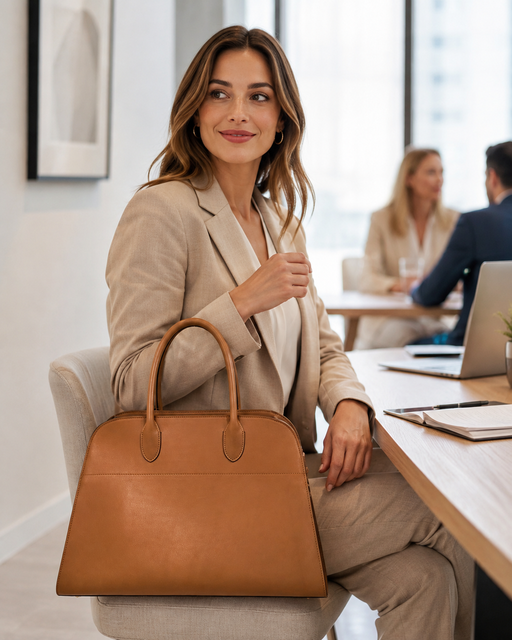 Woman carrying a brown full-grain leather work tote in an office