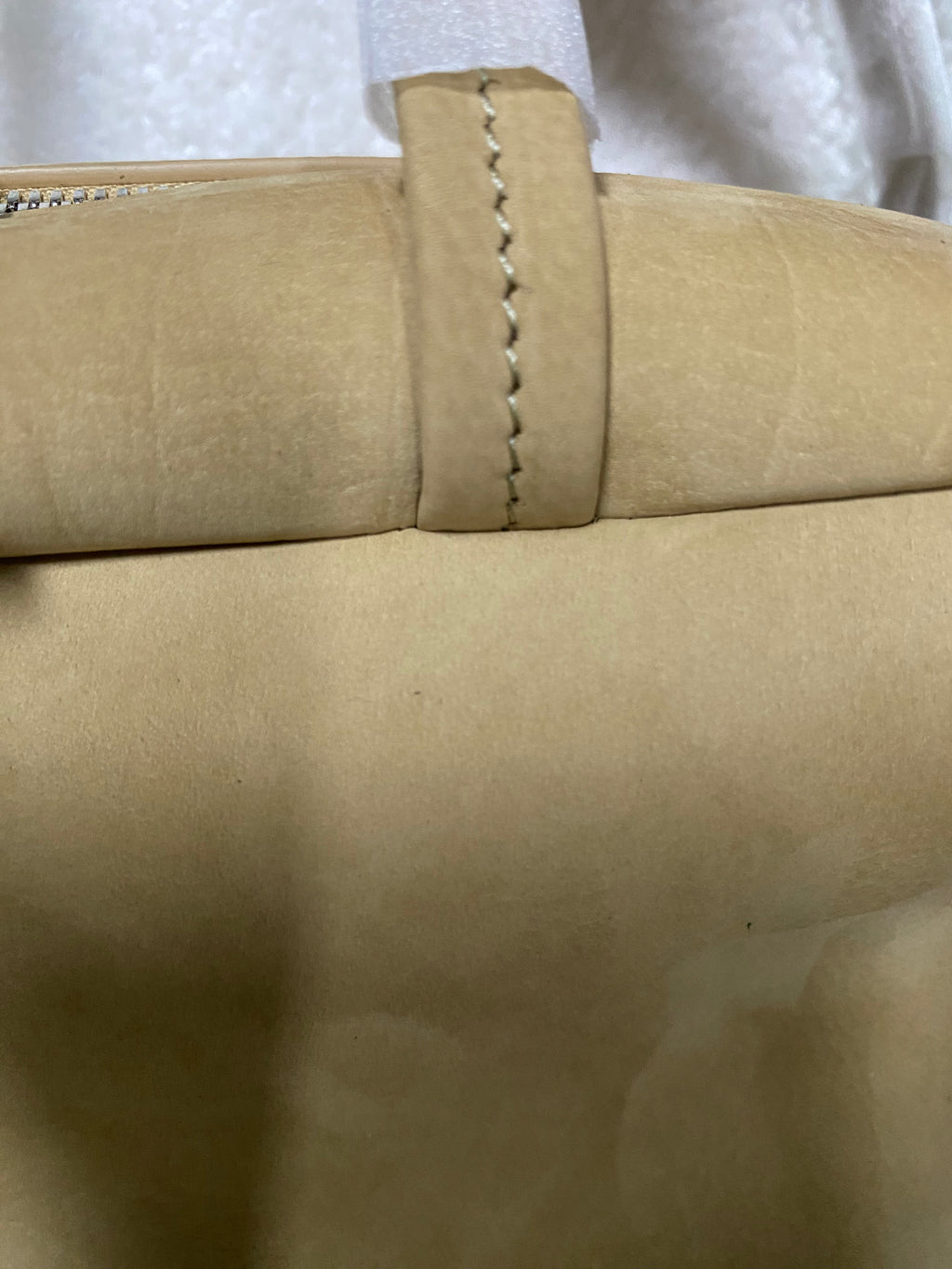 Stitched shoulder-strap attachment on camel calfskin bag