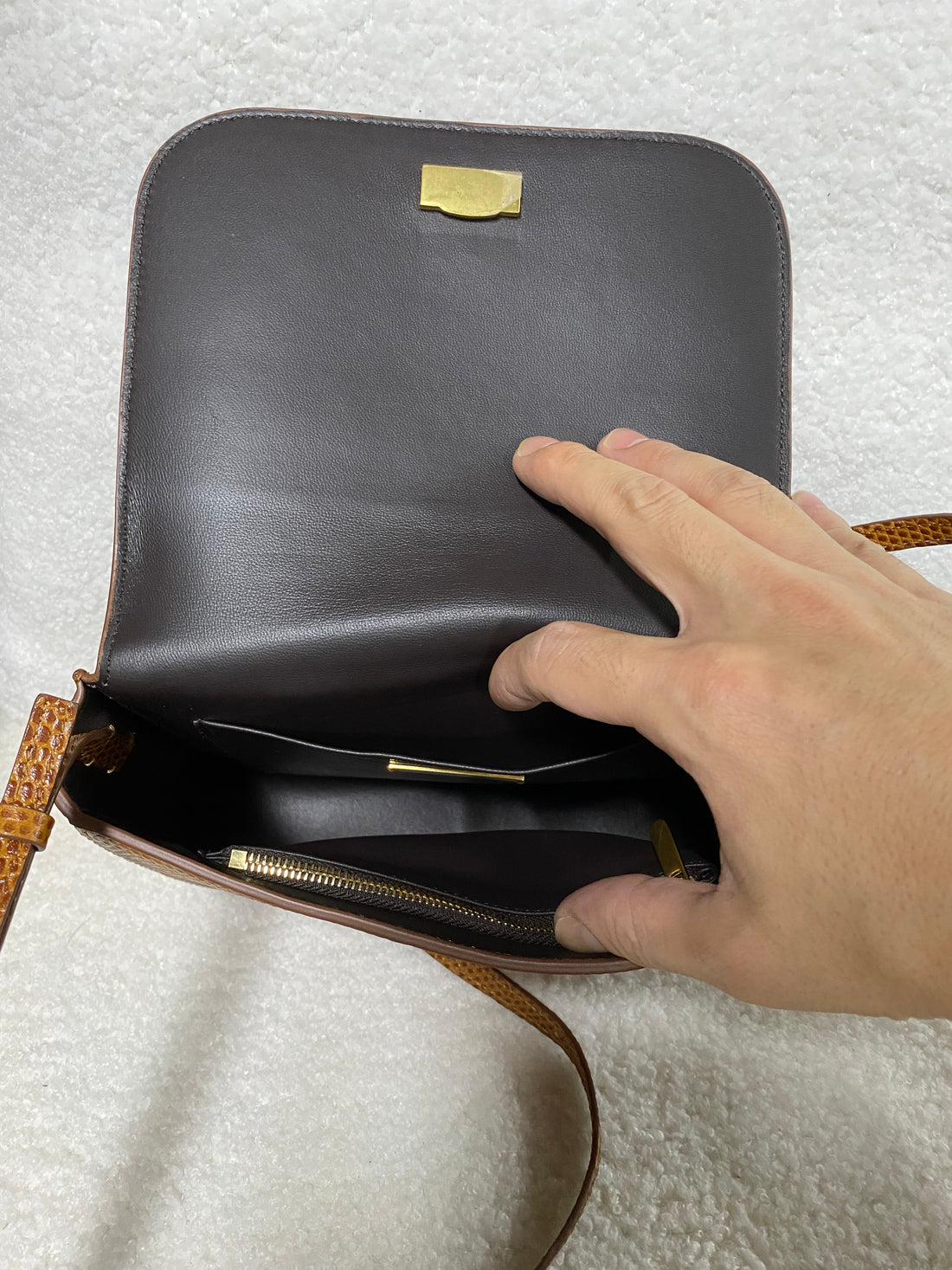 Interior view showing smooth black leather lining and gold zip pocket