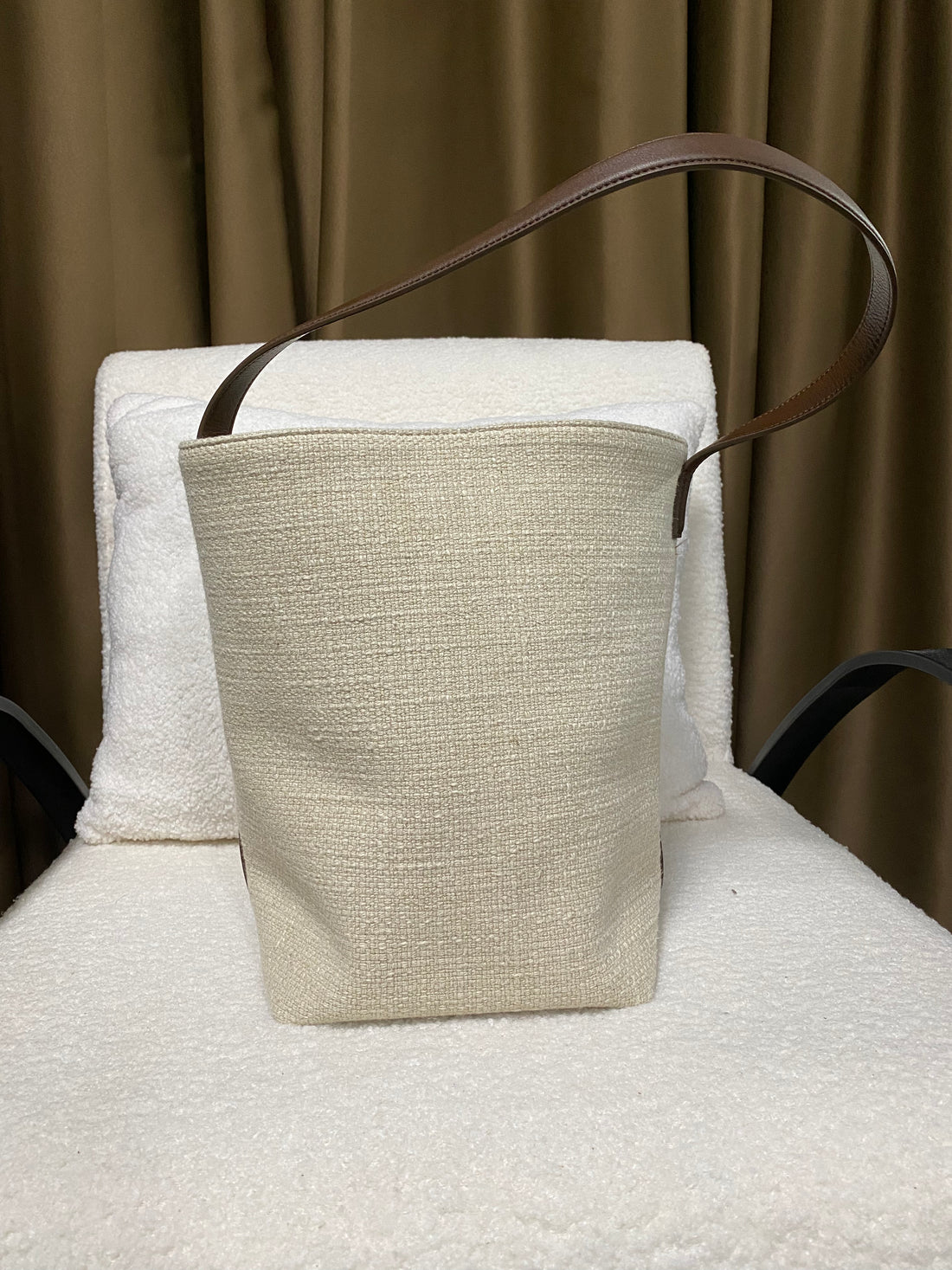 Natural linen bucket tote front view with full-grain leather shoulder strap