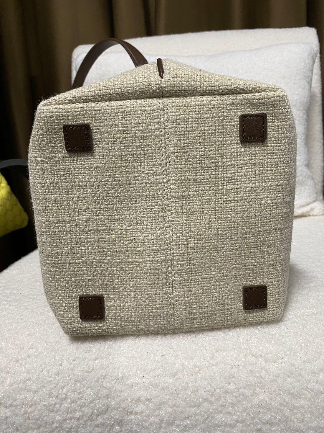 Reinforced base of linen bucket tote with four leather feet