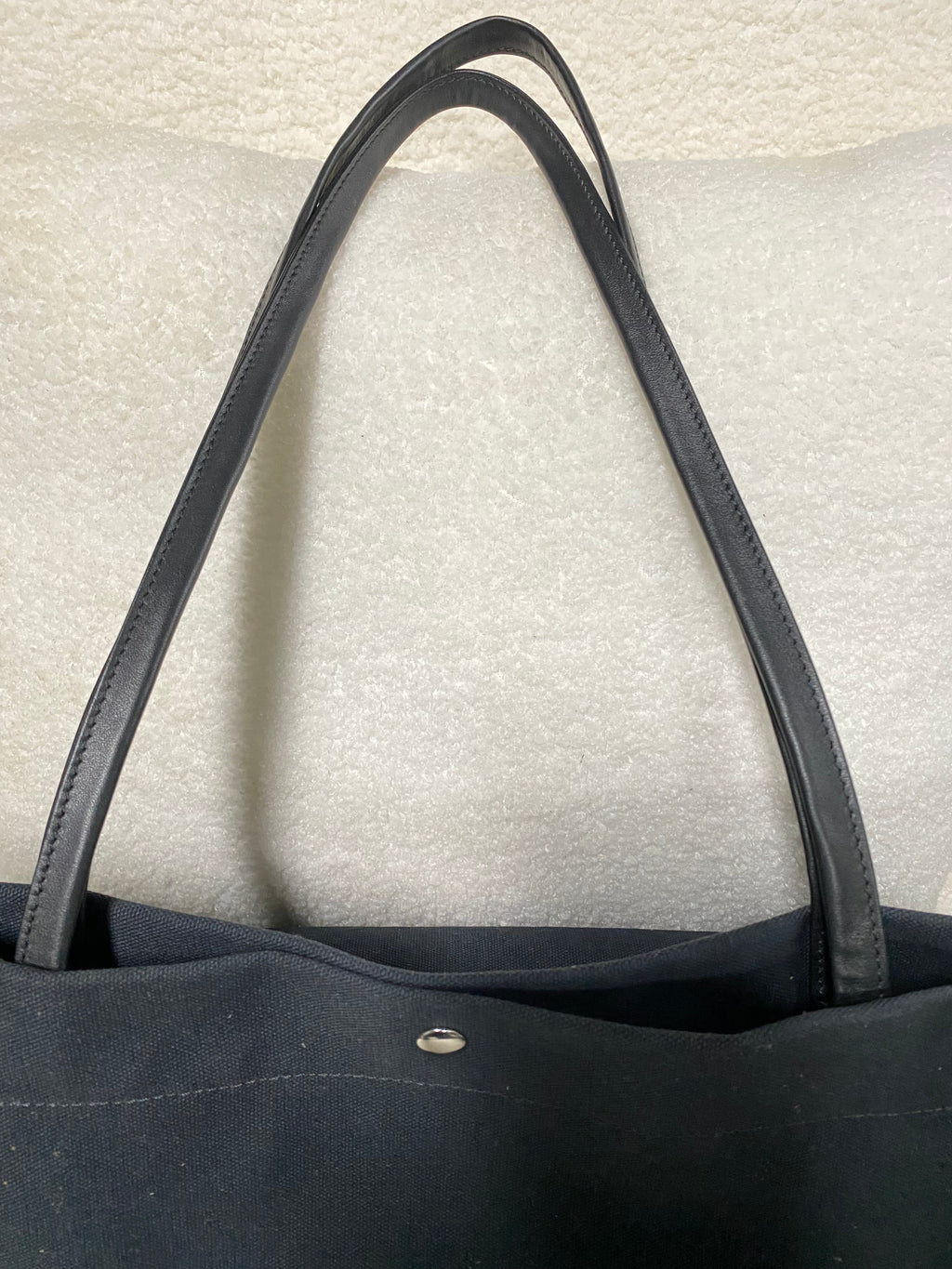 Genuine leather shoulder straps on navy canvas tote