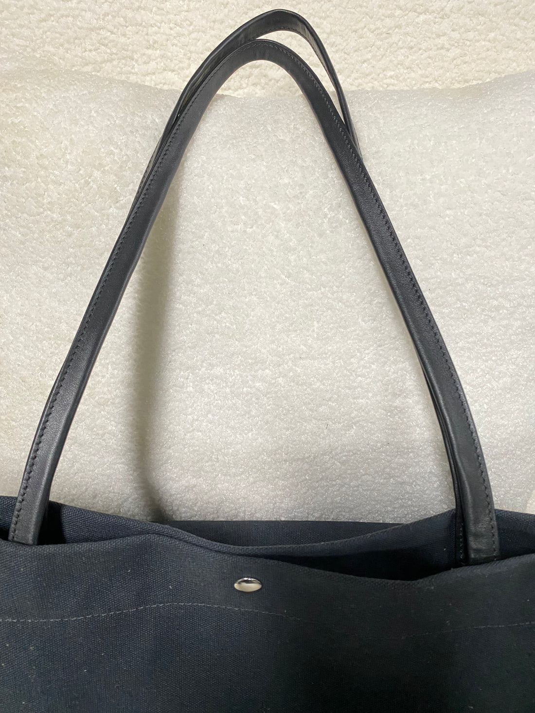 Genuine leather shoulder straps on navy canvas tote