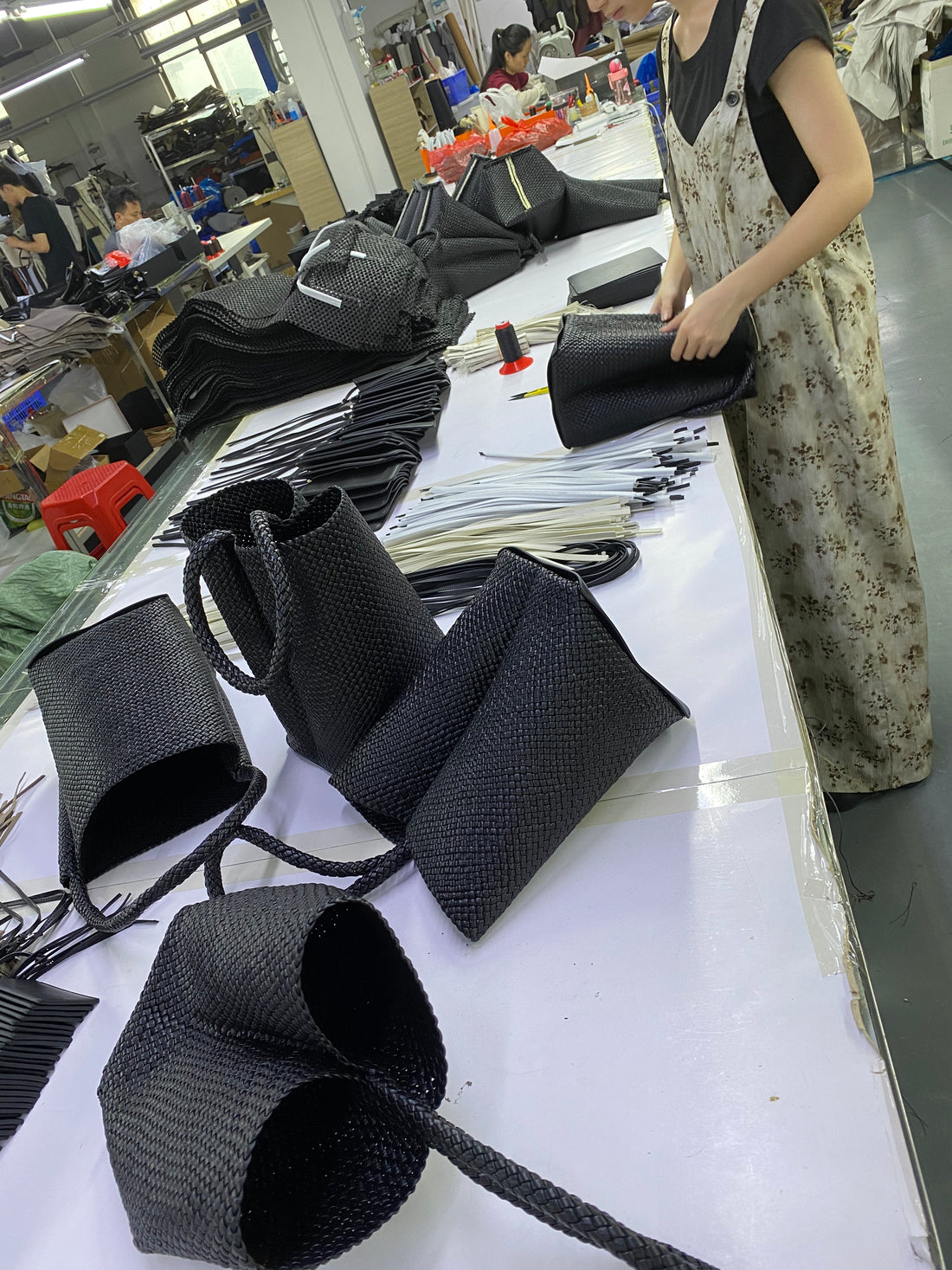 Logo-free black handwoven lambskin bucket bag — woven leather pieces during production