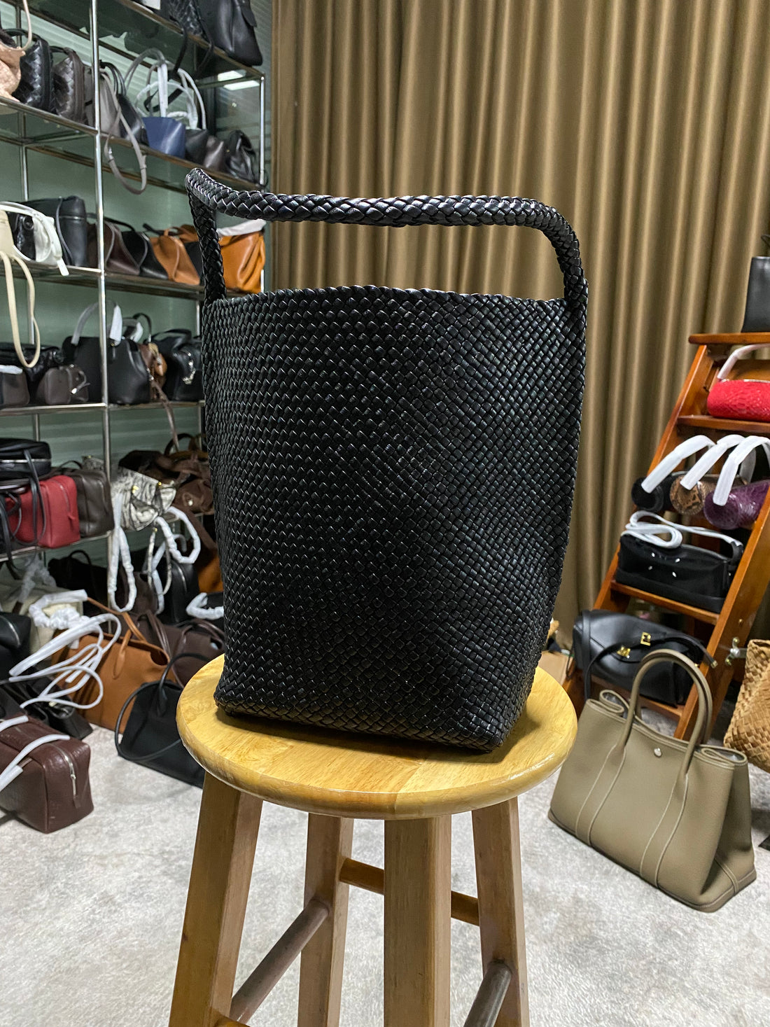 Logo-free black handwoven lambskin bucket bag — front view in a workshop