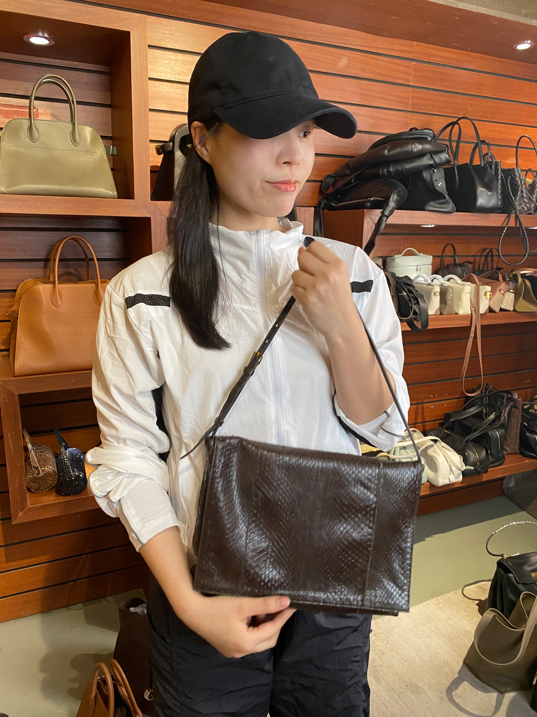 Brown genuine python leather shoulder bag — worn crossbody in a boutique