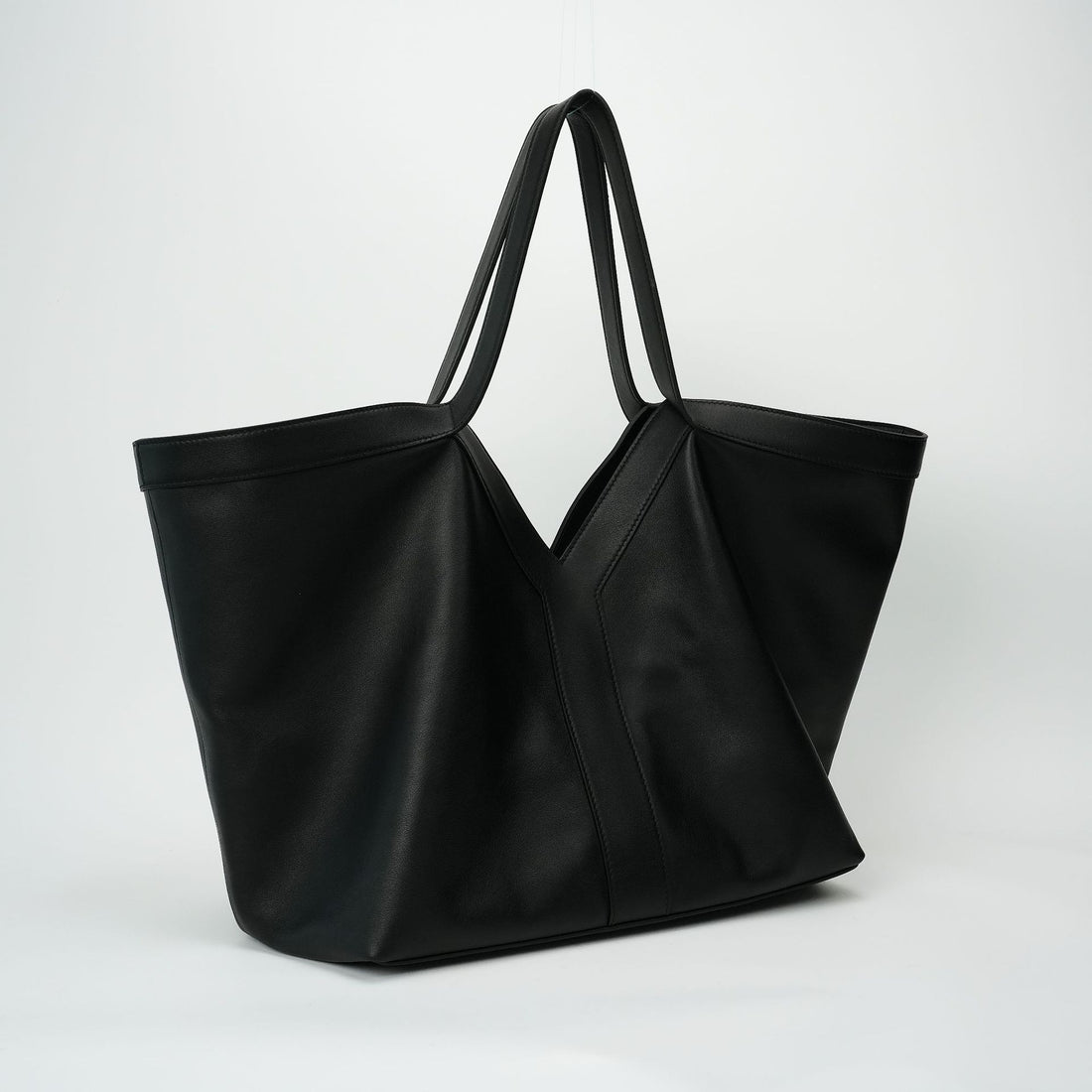 Logo-free black Y-strap slouchy leather tote — side-angle view