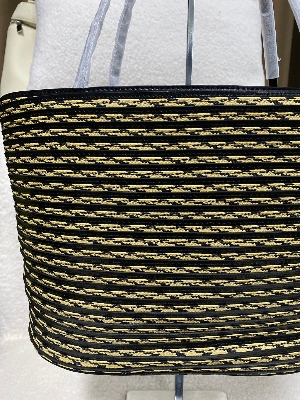 Logo-free handwoven striped bucket tote — woven stripe texture close-up
