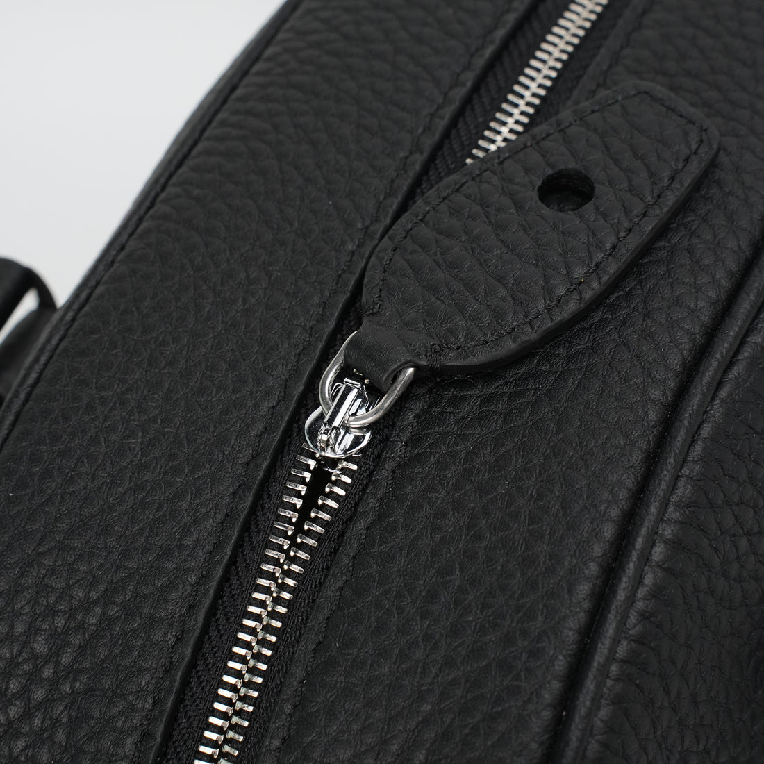 Logo-free full-grain cowhide top-handle bag — silver zipper and closure tab detail