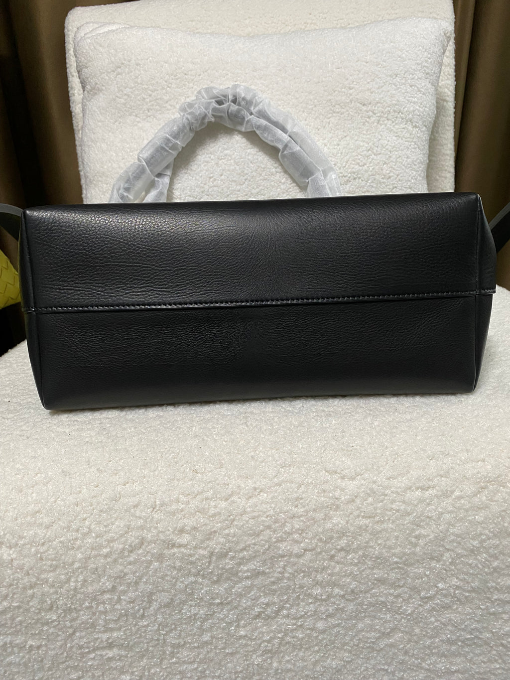 Flat leather base of black baby calfskin tote bag