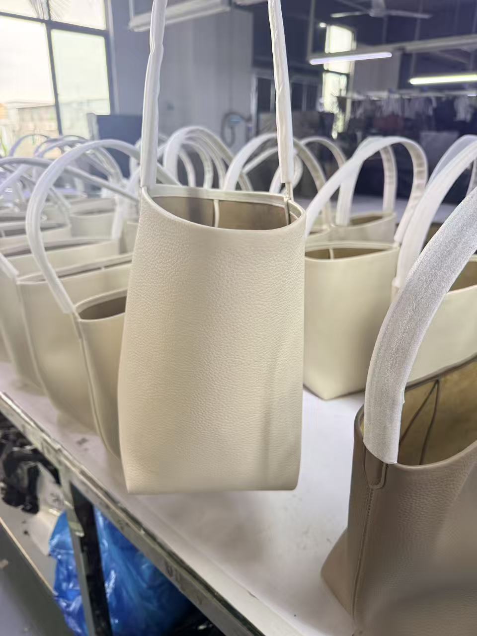 Minimalist tan leather shoulder tote — cream version during production