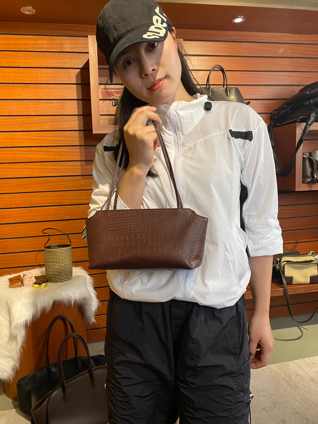 Logo-free full-grain cowhide shoulder tote — brown version held in a boutique