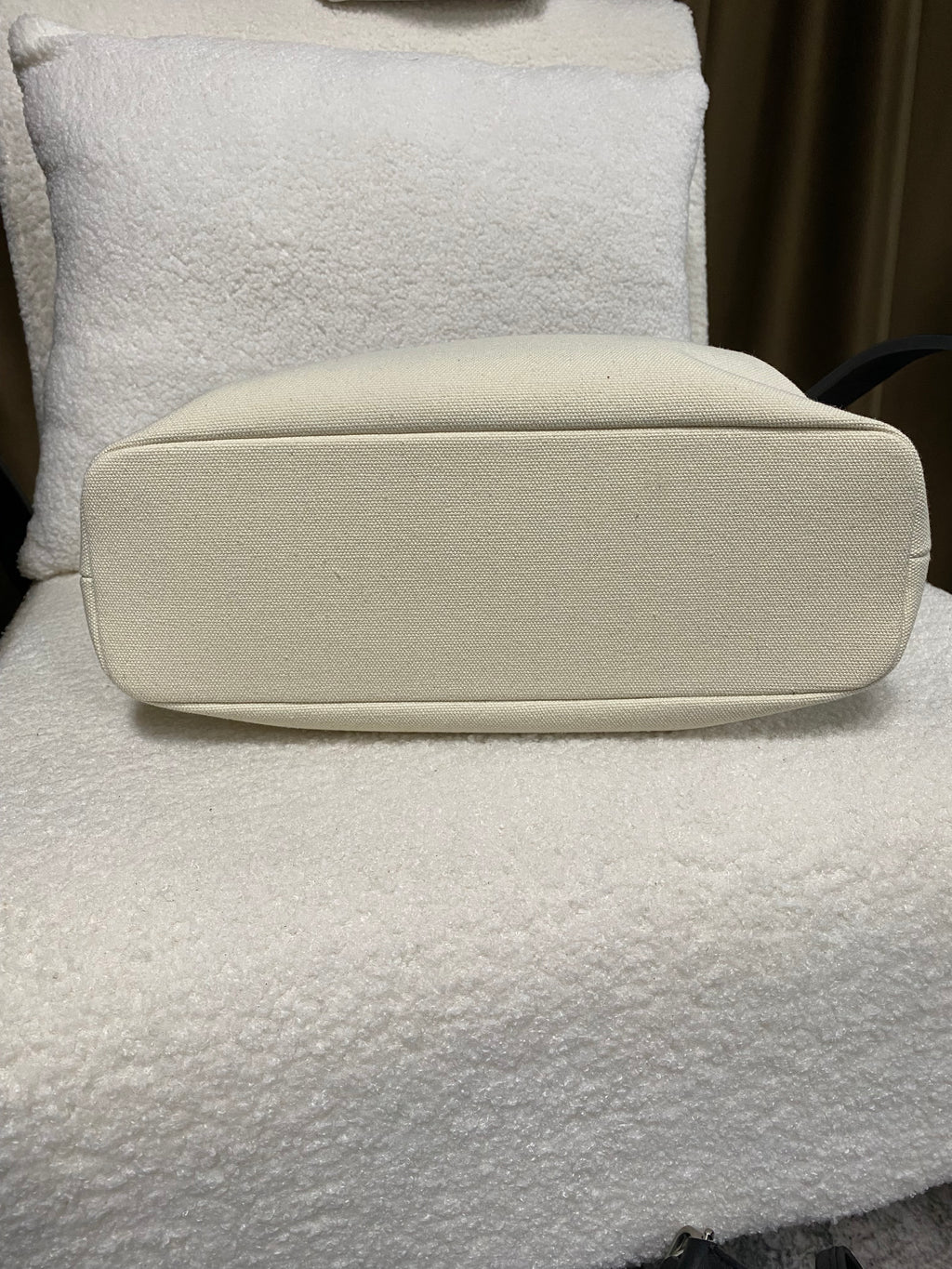 Flat cream leather base of structured linen handbag