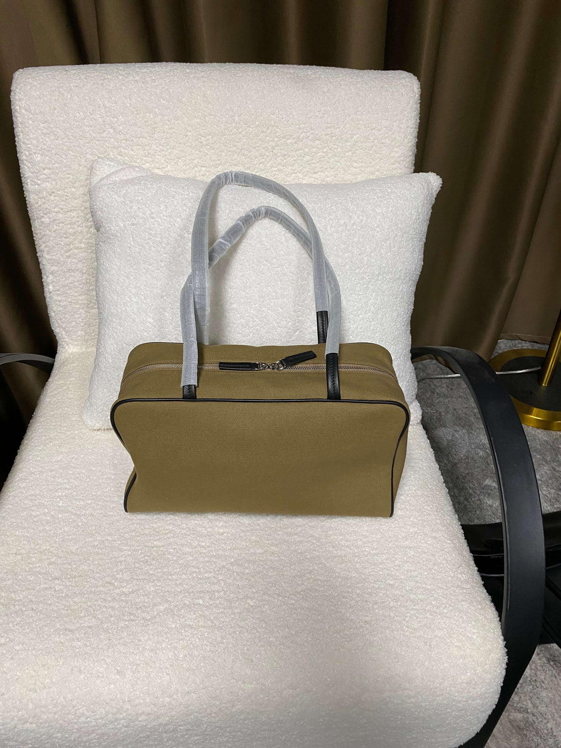 Logo-free canvas and lambskin commuter tote — front view on a white chair