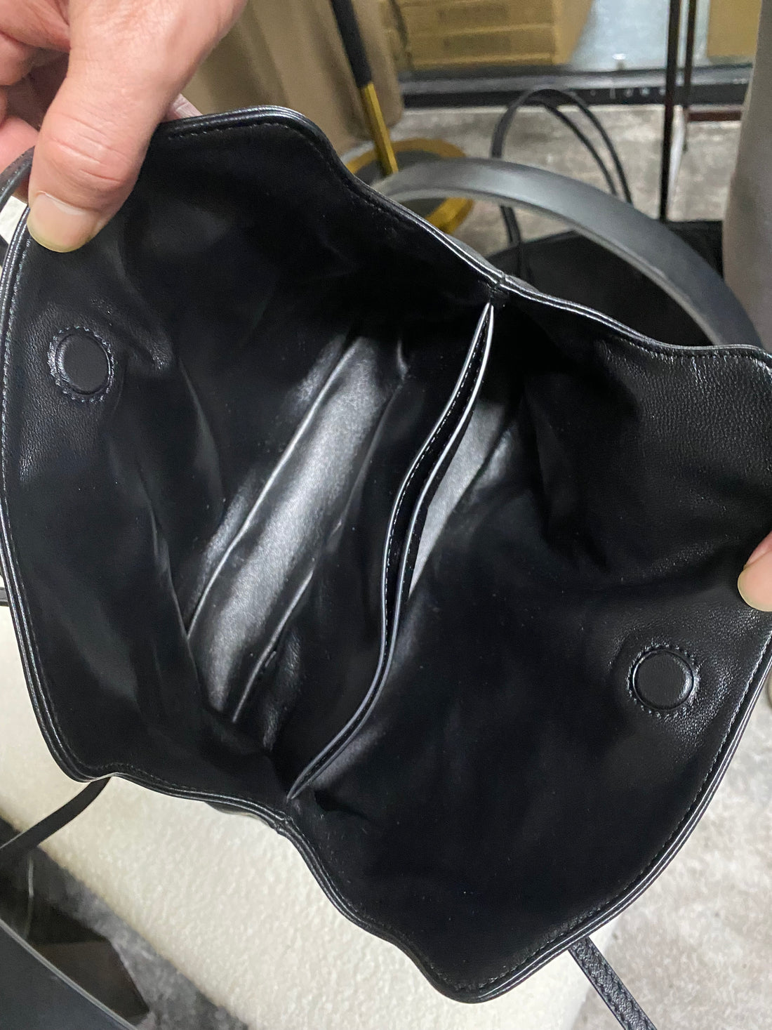 Black ruched lambskin crossbody bag — open interior with magnetic snap closures