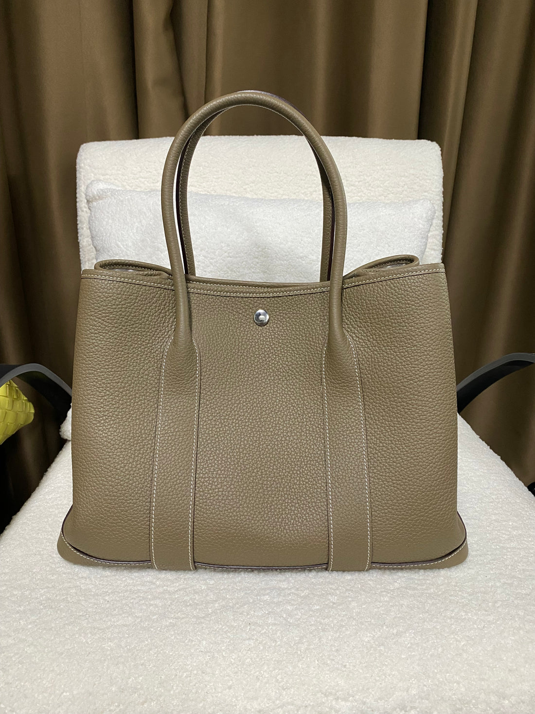 Taupe wide-top leather snap tote front view on display