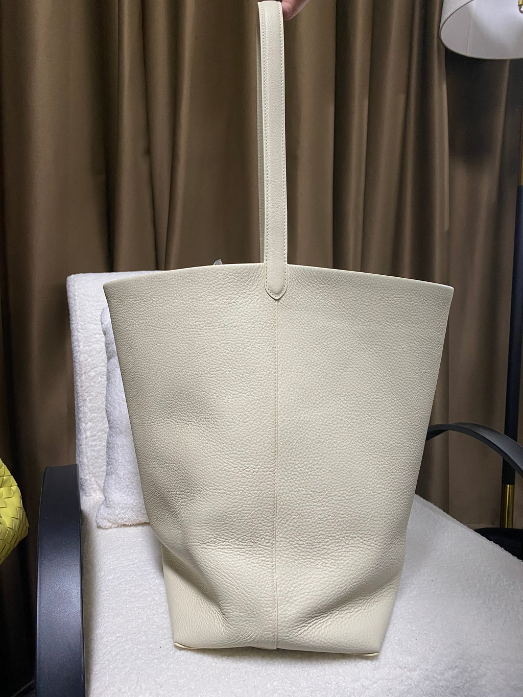 Cream slouchy leather bucket tote front view with wide opening