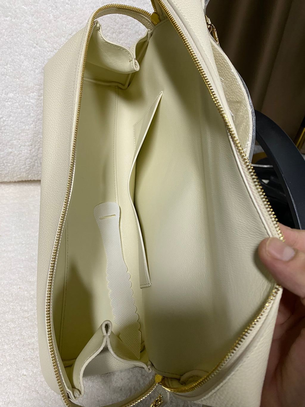 Open cream-lined interior of structured leather shoulder bag