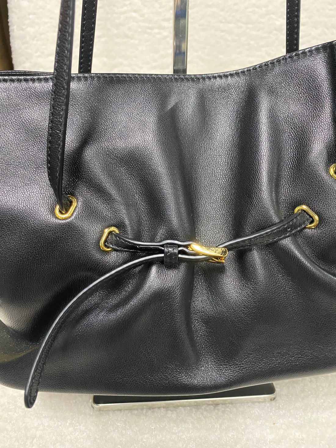 Black ruched lambskin crossbody bag — ruched front panel close-up