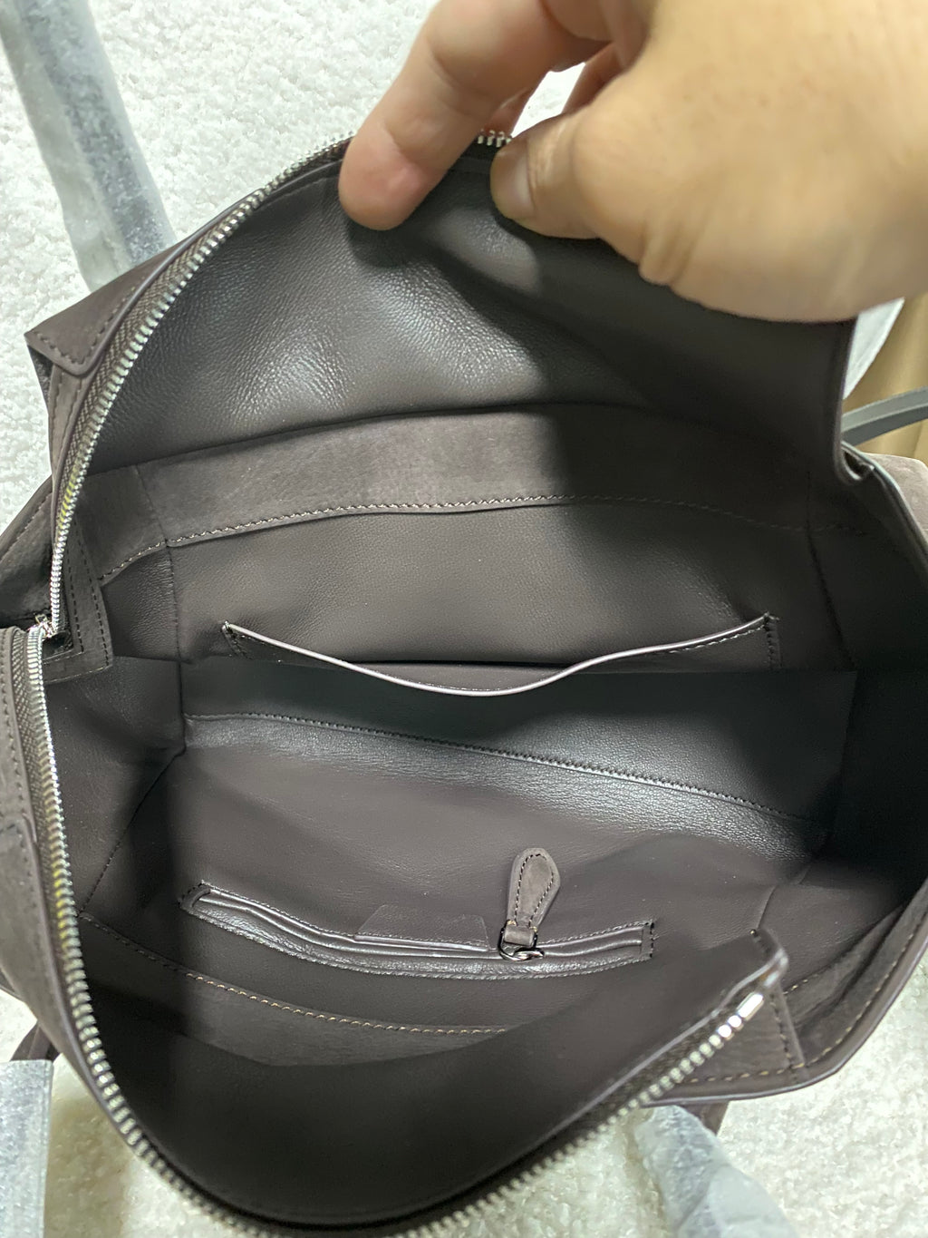 Open grey-lined interior of dark brown calfskin tote