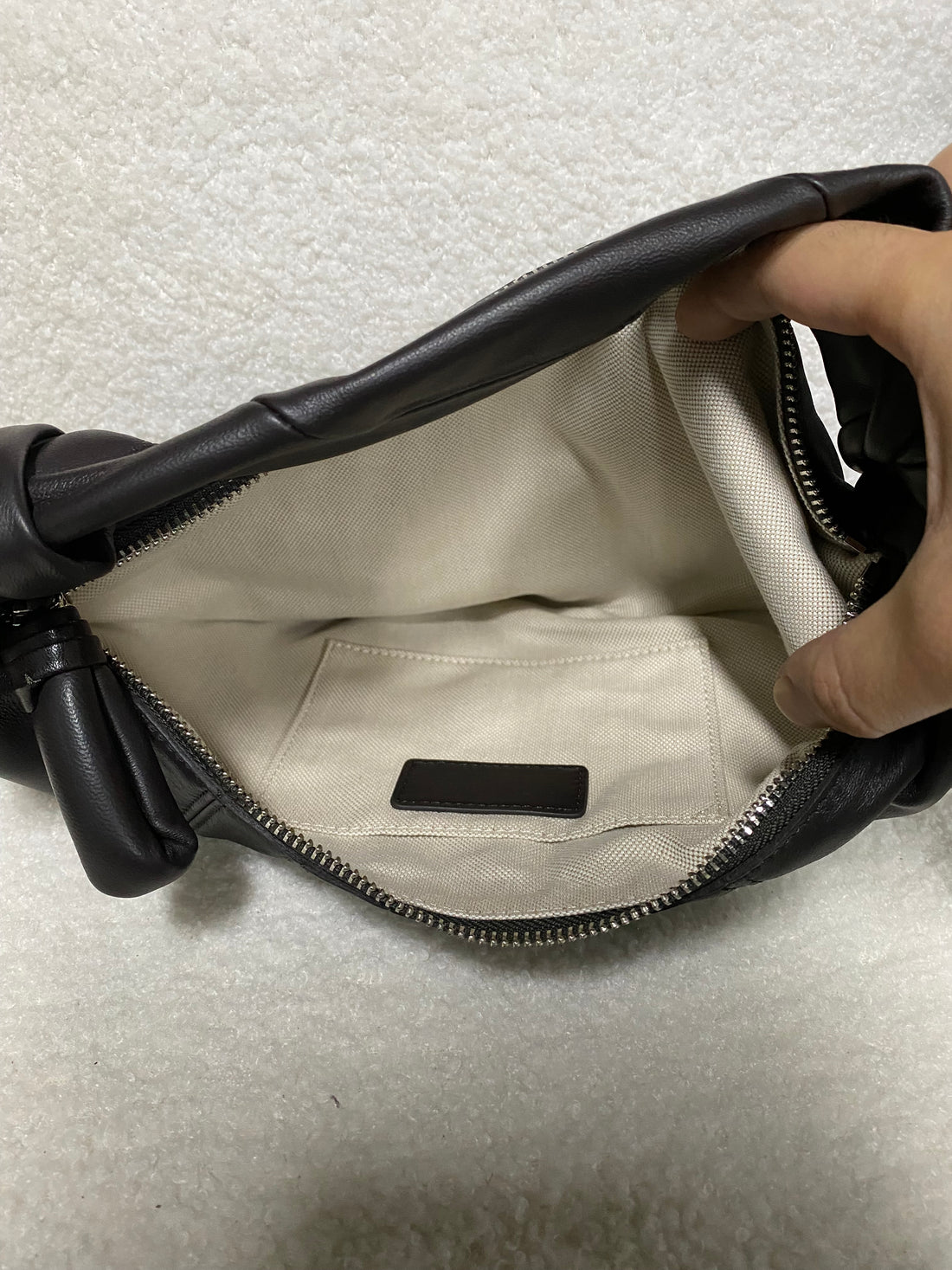 Open fabric-lined interior of black lambskin croissant hobo bag