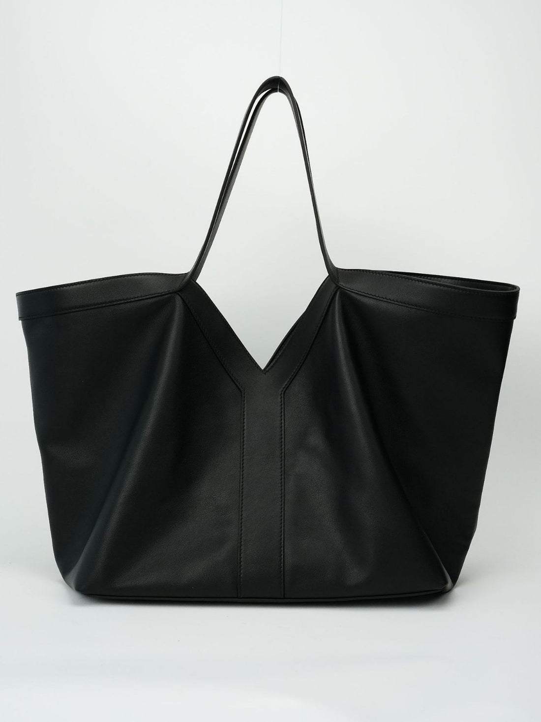 Logo-free black Y-strap slouchy leather tote — front view on white