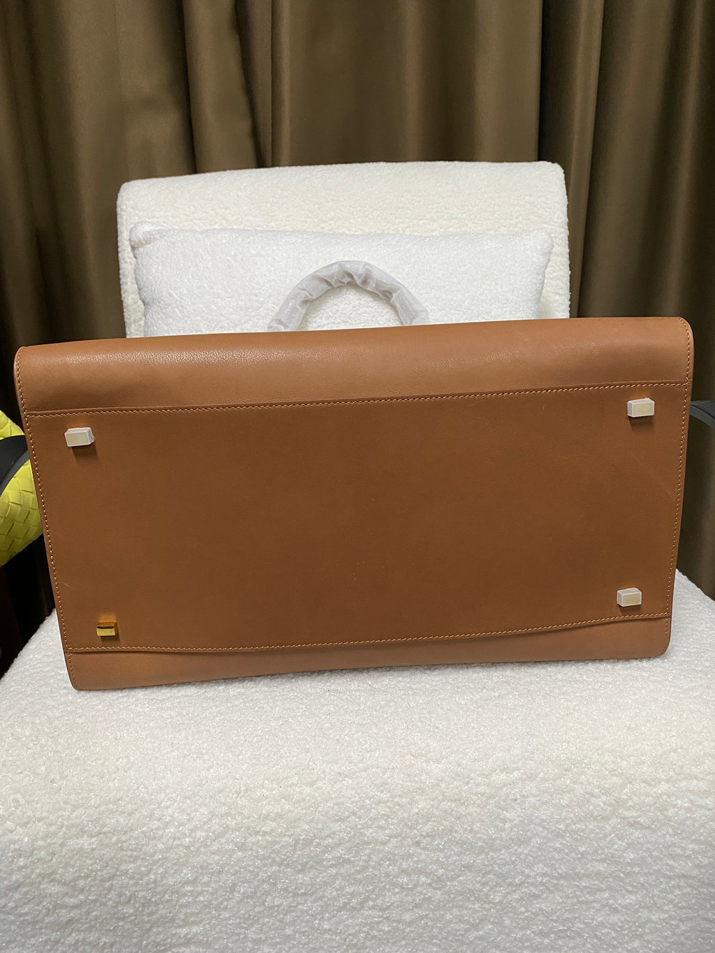 Reinforced base and protective feet on brown cowhide tote