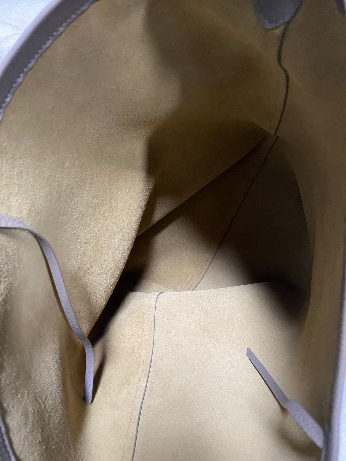 Interior pocket and suede lining inside full-grain leather bucket tote